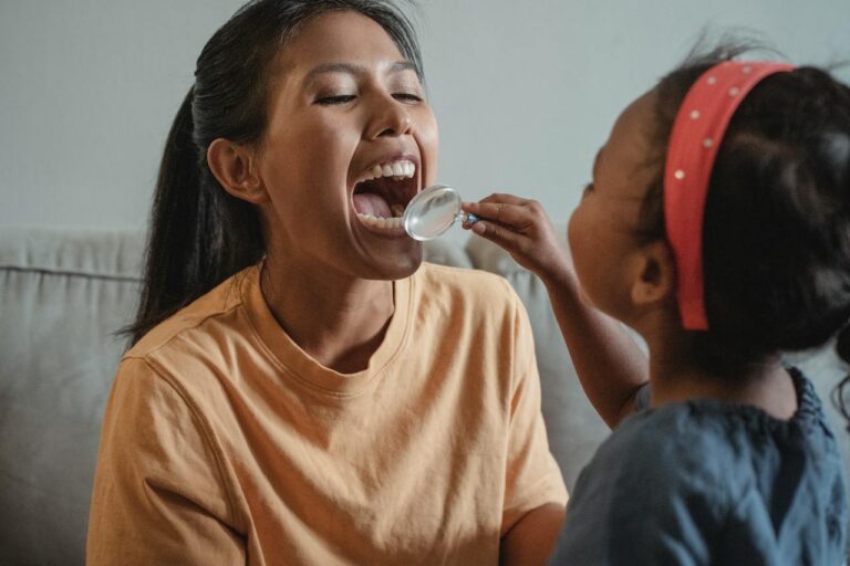 daughter using a magnifying glass to look at mother's mouth